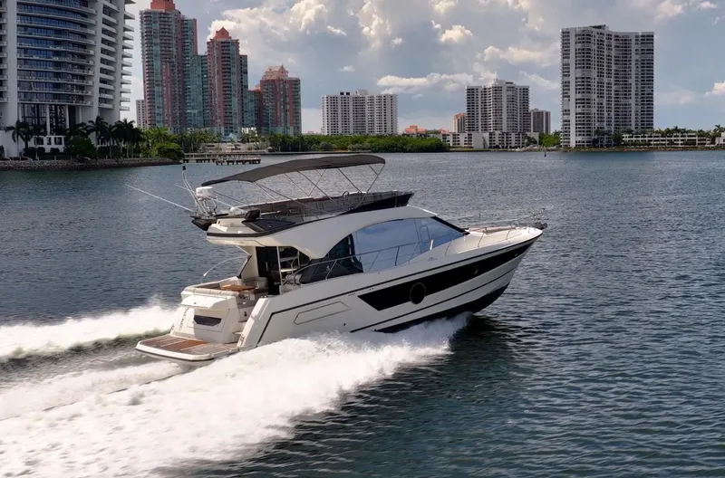 Kedem Plus Yacht Photos Pics 2021 Beneteau Monte Carlo 52 yacht cruising near city skyline on a sunny day.