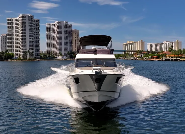 Kedem Plus Yacht Photos Pics 2021 Beneteau Monte Carlo 52 yacht cruising near modern city skyline.