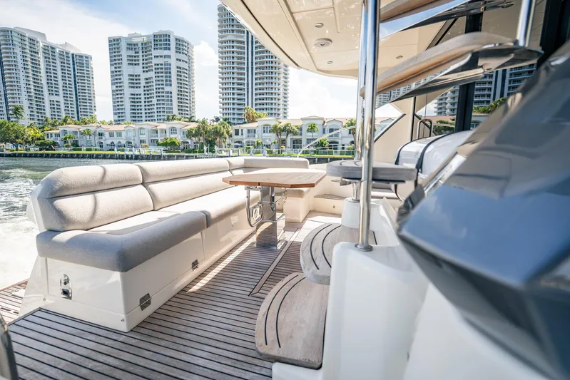 Kedem Plus Yacht Photos Pics Luxurious 2021 Beneteau Monte Carlo 52 yacht deck with seating, cityscape in background.