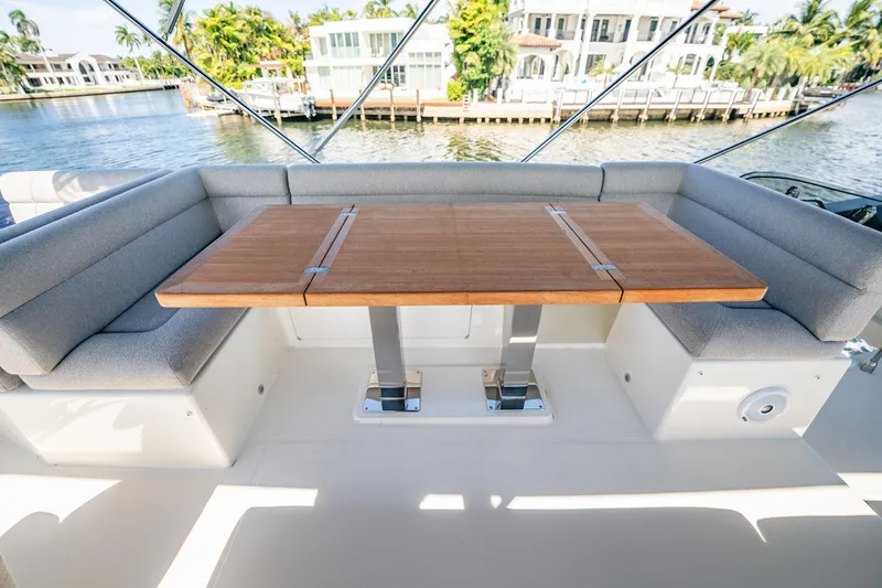 Kedem Plus Yacht Photos Pics Luxury seating area on 2021 Beneteau Monte Carlo 52 yacht, featuring a wooden table.