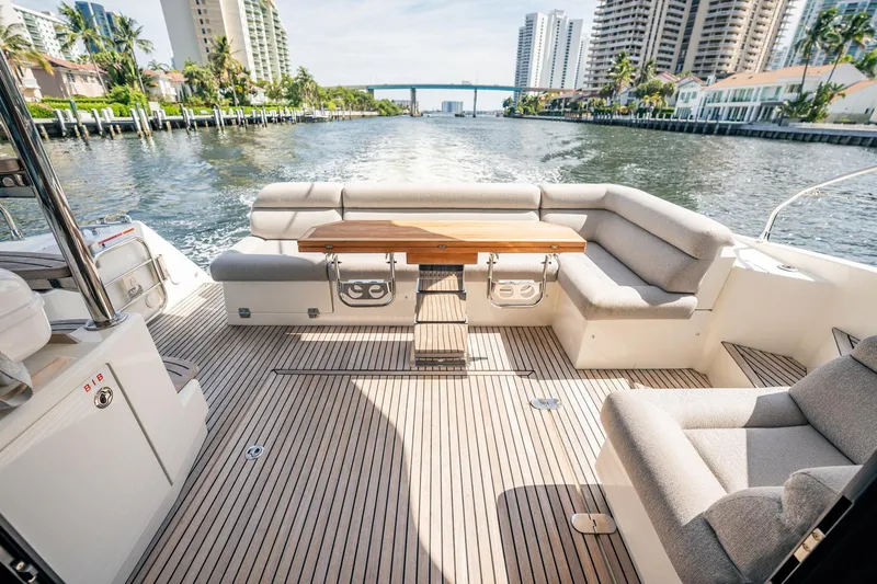 Kedem Plus Yacht Photos Pics Luxurious 2021 Beneteau Monte Carlo 52 yacht deck with elegant seating and scenic waterfront view.