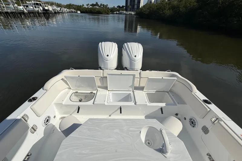  Yacht Photos Pics 2025 Sea Hunt Escape 28 boat with open storage compartments and dual engines on calm water.