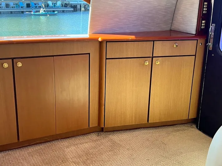 Reel Interest Yacht Photos Pics Interior of 2002 Ocean Yachts 56 Super Sport with wooden cabinets and waterfront view.