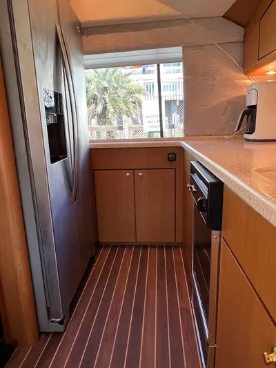 Reel Interest Yacht Photos Pics Galley kitchen in 2002 Ocean Yachts 56 Super Sport with wood flooring and modern appliances.