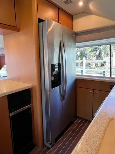 Reel Interest Yacht Photos Pics 2002 Ocean Yachts 56 Super Sport kitchen with stainless steel refrigerator and wooden cabinetry.