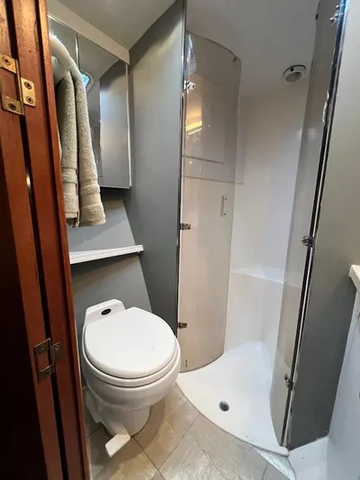Reel Interest Yacht Photos Pics 2002 Ocean Yachts 56 Super Sport bathroom with shower, toilet, and towels.