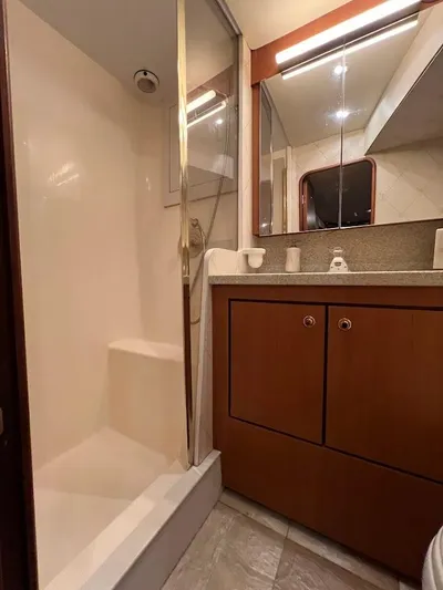 Reel Interest Yacht Photos Pics Bathroom interior of 2002 Ocean Yachts 56 Super Sport with shower and wooden cabinetry.