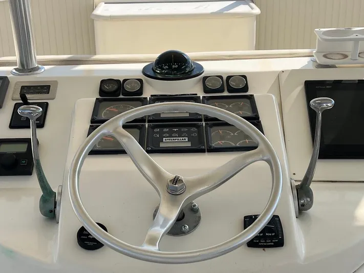 Reel Interest Yacht Photos Pics Helm of 2002 Ocean Yachts 56 Super Sport with steering wheel and controls.