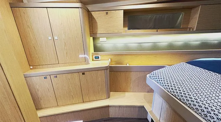 New Horizon Yacht Photos Pics Interior of 2018 Beneteau Oceanis 45 yacht, featuring wooden cabinetry and a cozy sleeping area.
