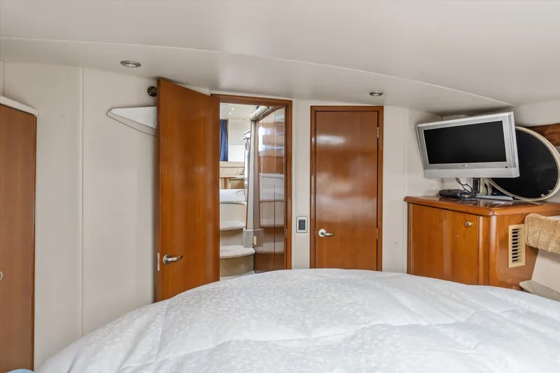 Barbarrick Yacht Photos Pics Interior of 2006 Meridian 411 Sedan yacht bedroom with TV and wooden cabinetry.