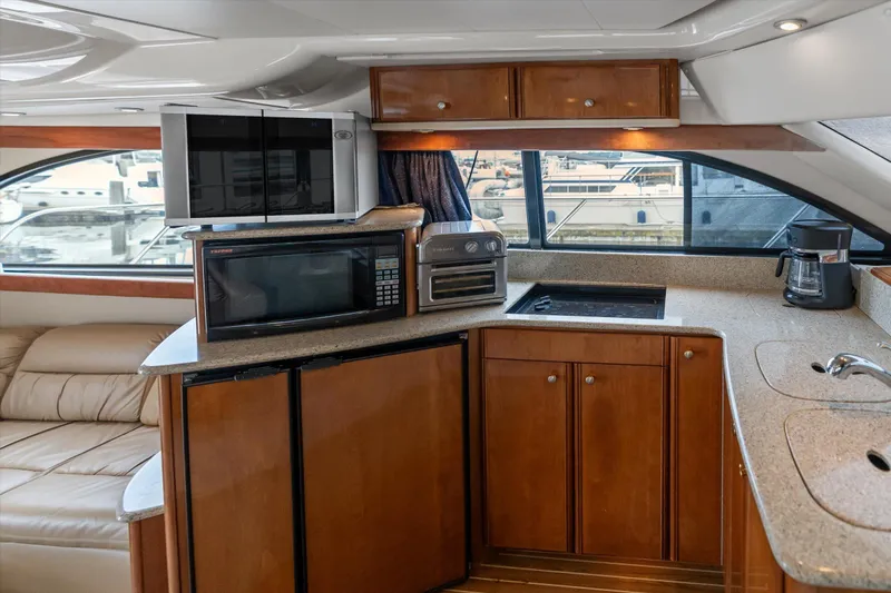 Barbarrick Yacht Photos Pics Interior of 2006 Meridian 411 Sedan yacht with kitchen appliances and wooden cabinetry.