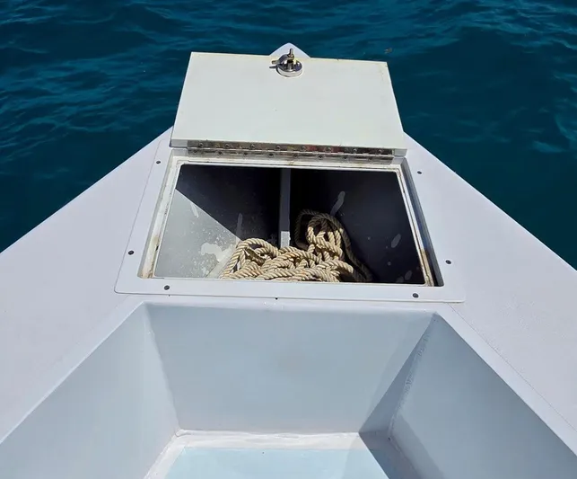  Yacht Photos Pics 2012 Contender Custom 33 Center Console with open storage compartment and rope, on blue water.