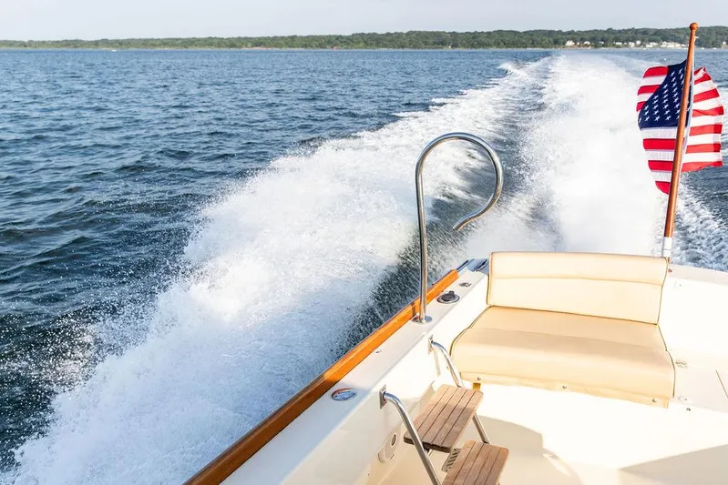 Cheetah Yacht Photos Pics Hinckley T29 CC 2014 boat cruising on open water with American flag.