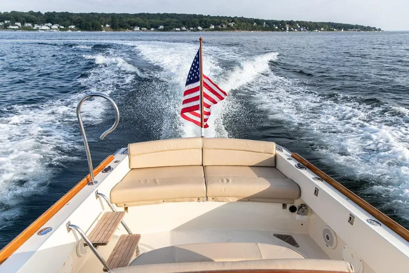 Cheetah Yacht Photos Pics 2014 Hinckley T29 CC boat cruising with American flag, scenic ocean view.