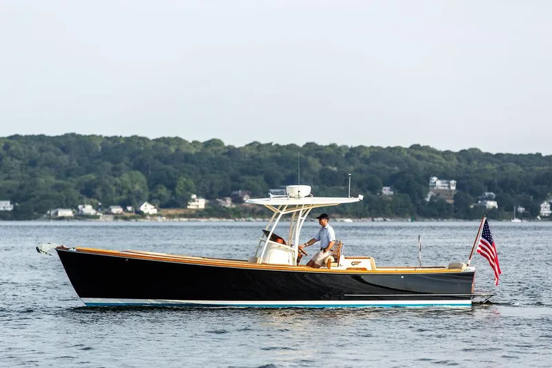 Cheetah Yacht Photos Pics 2014 Hinckley T29 CC boat cruising on a calm lake with forested shoreline.