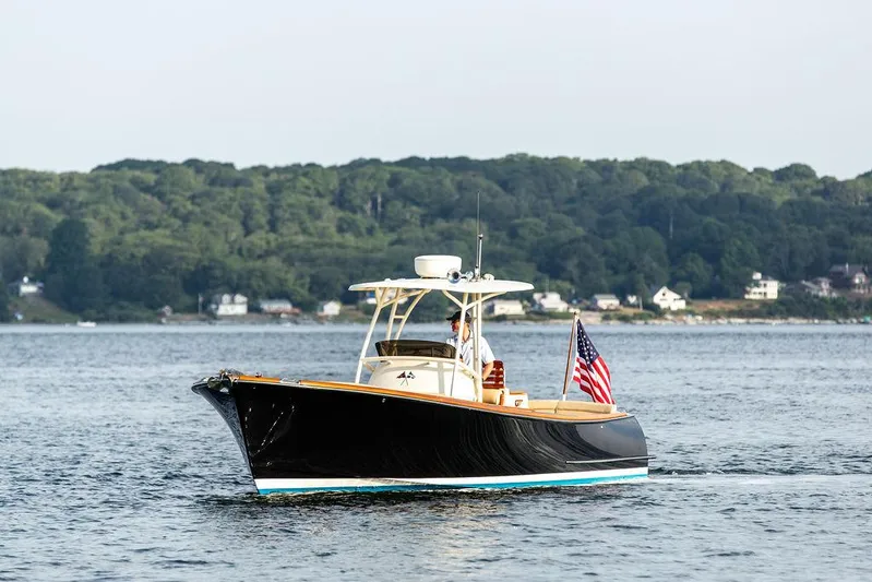 Cheetah Yacht Photos Pics 2014 Hinckley T29 CC boat cruising on a calm lake with forested shoreline.