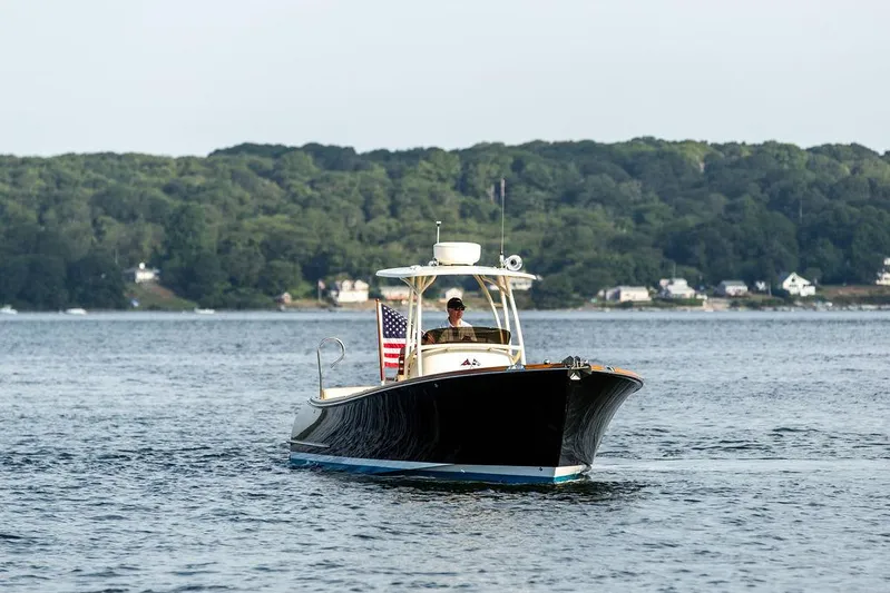 Cheetah Yacht Photos Pics 2014 Hinckley T29 CC boat cruising on a calm lake with forested shoreline.