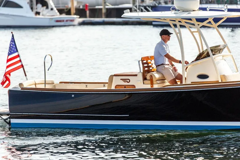 Cheetah Yacht Photos Pics 2014 Hinckley T29 CC boat on water, American flag, person steering.