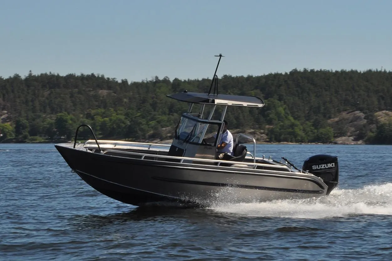 2024 Arronet 20 5 SPT boat cruising on a scenic lake with forested shoreline.
