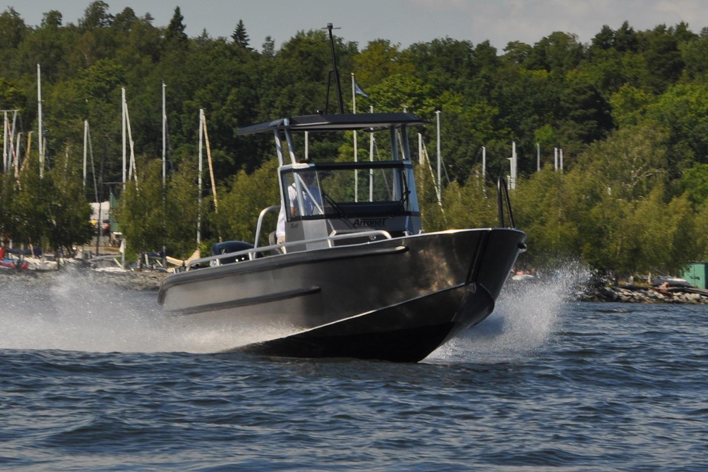 2024 Arronet 20 5 SPT boat speeding on a lake with forested background.