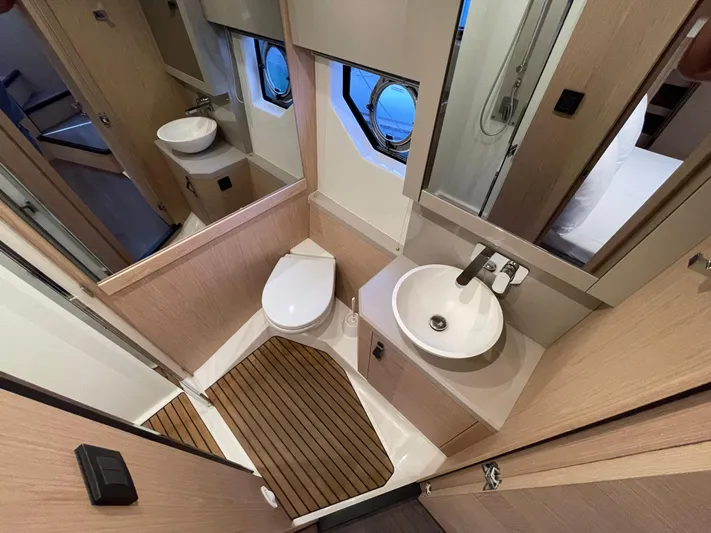  Yacht Photos Pics Bathroom interior of 2022 Beneteau Monte Carlo 52 yacht, featuring modern fixtures and wooden accents.