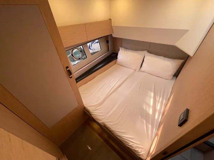  Yacht Photos Pics Cozy bedroom in 2022 Beneteau Monte Carlo 52 yacht with double bed and porthole window.