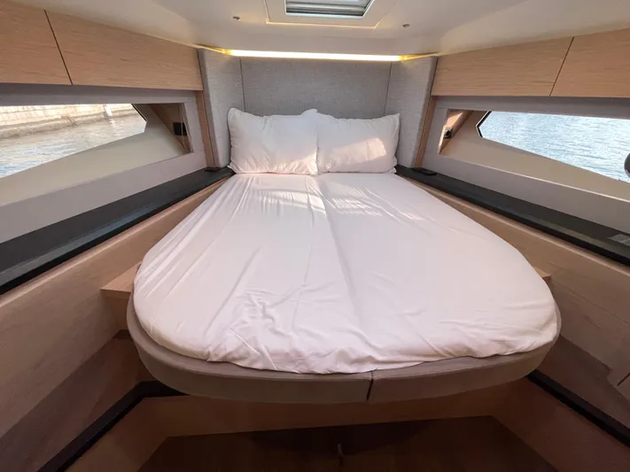  Yacht Photos Pics Luxurious bedroom interior of 2022 Beneteau Monte Carlo 52 yacht with elegant bedding.