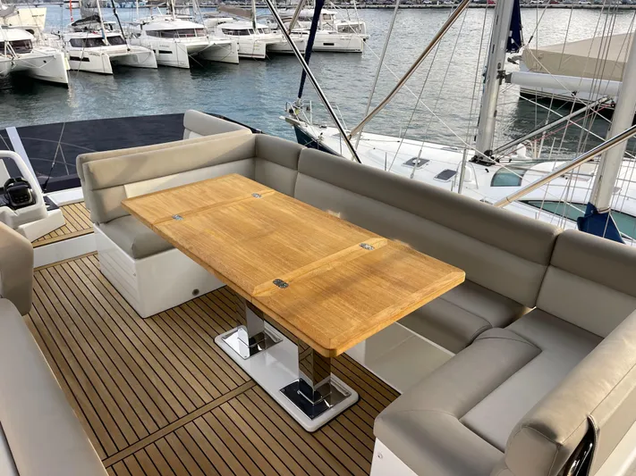  Yacht Photos Pics Luxurious 2022 Beneteau Monte Carlo 52 yacht deck with elegant seating and wooden table.
