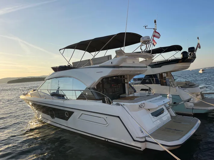  Yacht Photos Pics 2022 Beneteau Monte Carlo 52 yacht docked at sunset, featuring sleek design and spacious deck.