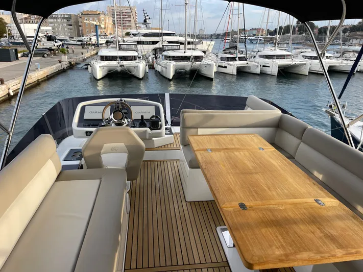  Yacht Photos Pics Luxurious 2022 Beneteau Monte Carlo 52 yacht interior with elegant seating and wooden table.