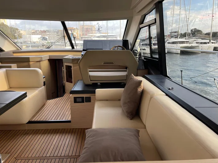  Yacht Photos Pics Luxurious interior of 2022 Beneteau Monte Carlo 52 yacht with elegant seating and scenic marina view.