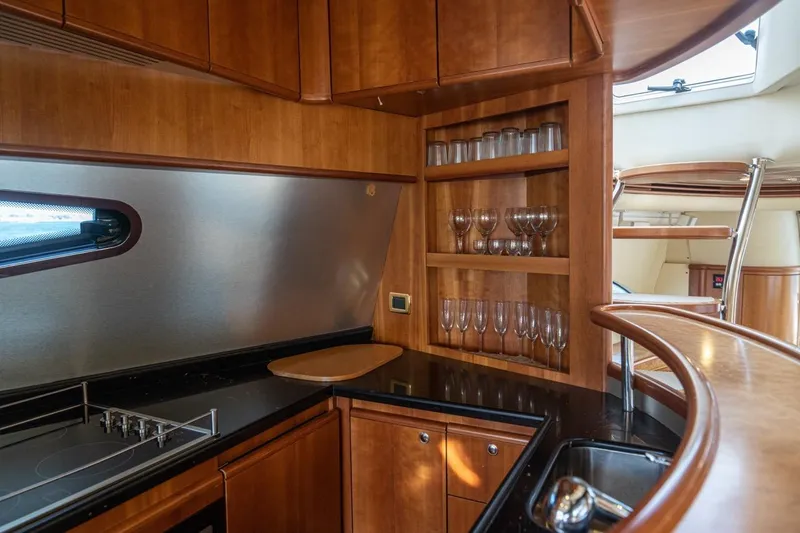 Richmind Yacht Photos Pics Luxurious 2007 Azimut 68E yacht kitchen with wooden cabinetry and glassware display.