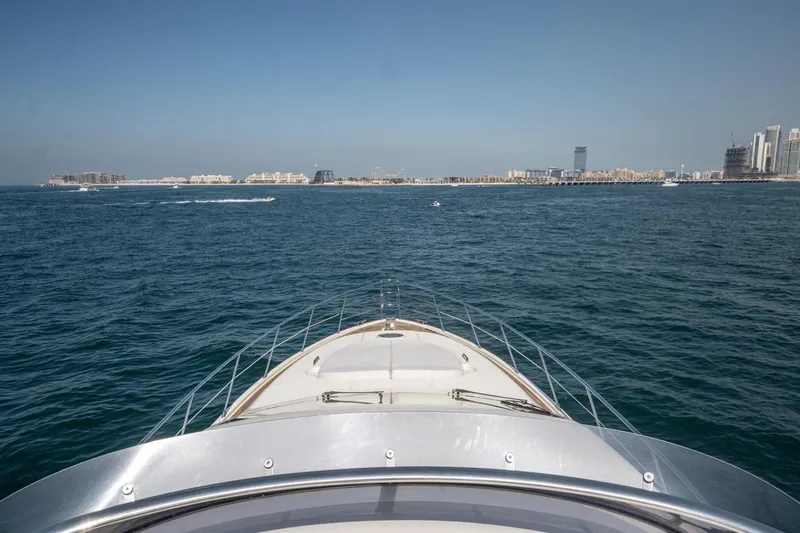 Richmind Yacht Photos Pics Bow view of 2007 Azimut 68E yacht cruising towards a distant city skyline.