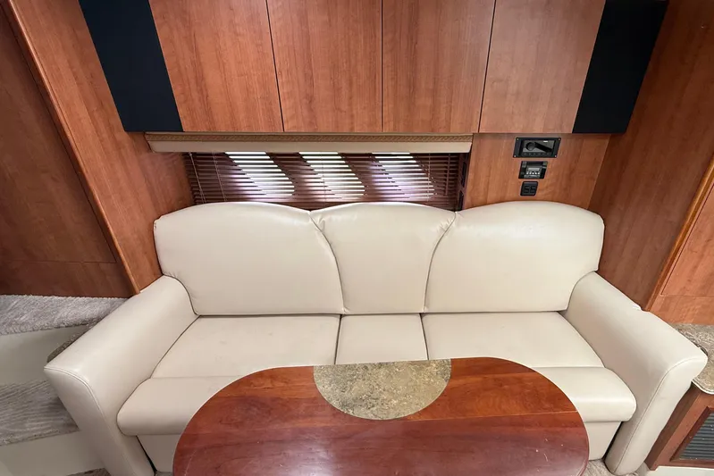  Yacht Photos Pics 2008 Cruisers Yachts 330 Express interior with beige sofa and wooden table.