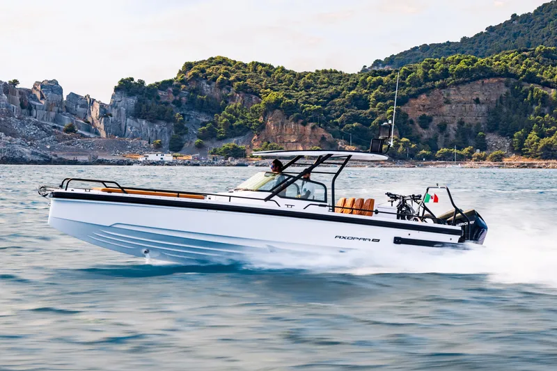 Yacht Photos Pics 2024 Axopar 28 T-Top boat cruising on scenic coastal waters.