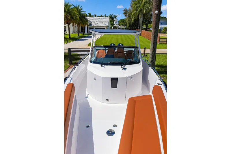  Yacht Photos Pics 2024 Axopar 28TT boat with sleek design and brown seating, docked near palm trees.