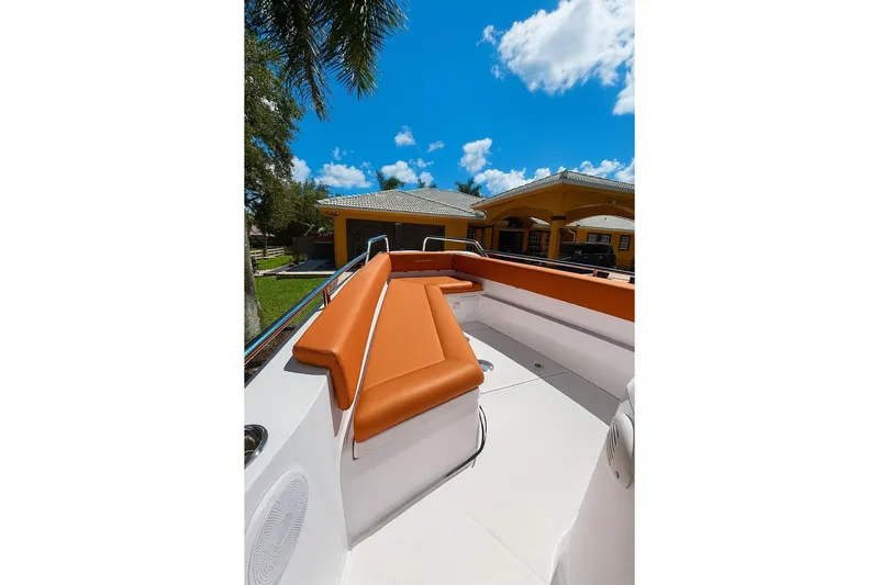  Yacht Photos Pics 2024 Axopar 28TT boat with orange seating, docked under a clear blue sky.