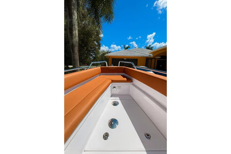  Yacht Photos Pics 2024 Axopar 28TT boat interior with orange seating under a clear blue sky.