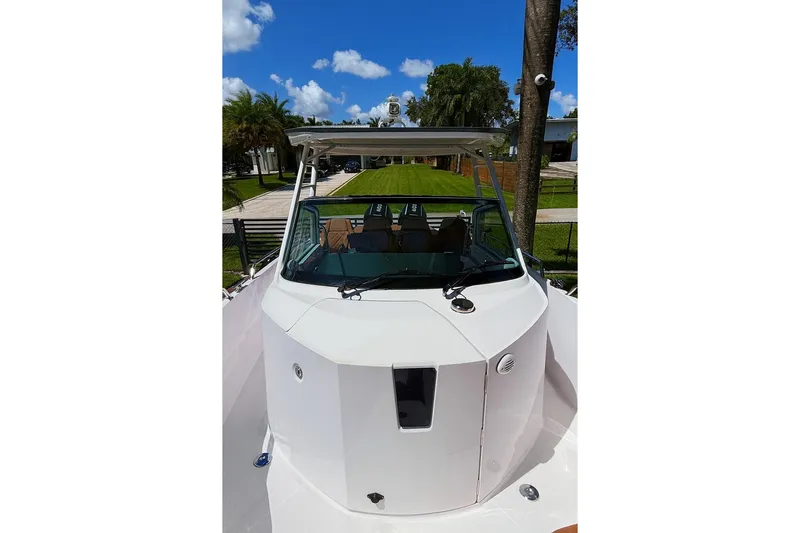  Yacht Photos Pics 2024 Axopar 28TT boat with sleek design, docked under clear blue sky.