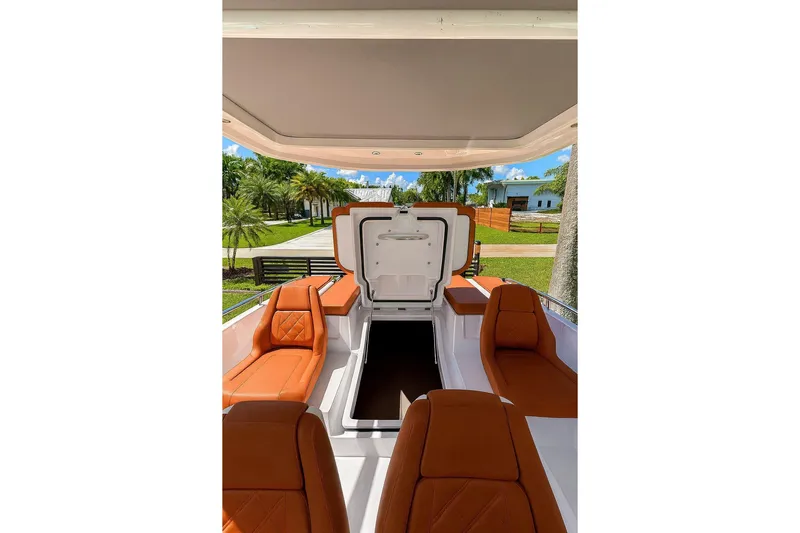  Yacht Photos Pics 2024 Axopar 28TT boat interior with orange seating and open storage compartment.