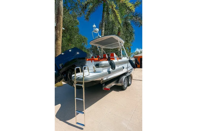  Yacht Photos Pics 2024 Axopar 28TT boat on trailer, surrounded by palm trees.