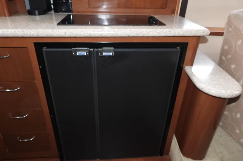  Yacht Photos Pics 2008 Carver 41 Cockpit Motor Yacht kitchen with black fridge and wooden cabinetry.