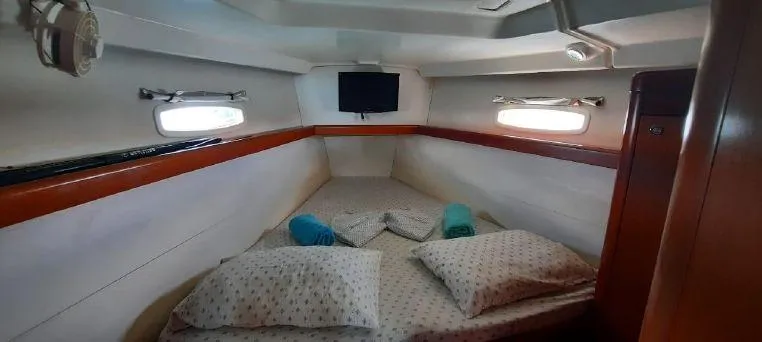 Latika Yacht Photos Pics Cozy cabin interior of 2011 Beneteau Oceanis 43 sailboat with bed, pillows, and portholes.