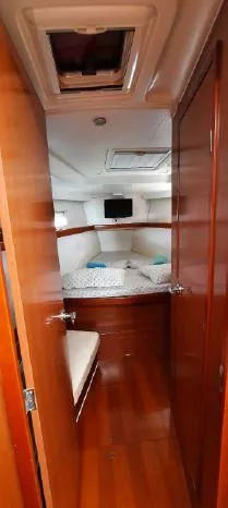 Latika Yacht Photos Pics Interior cabin of 2011 Beneteau Oceanis 43 sailboat with wood finish and cozy bedding.