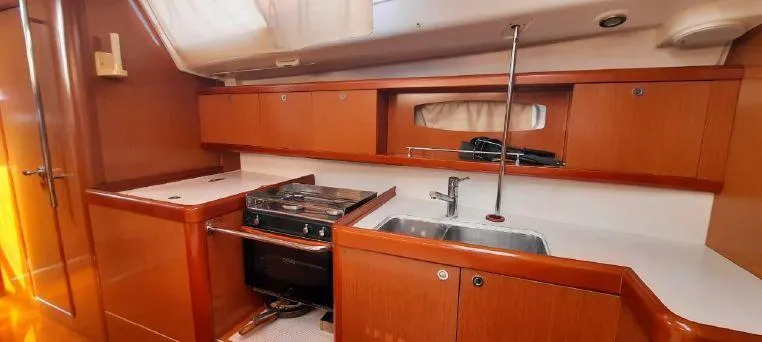 Latika Yacht Photos Pics Interior of 2011 Beneteau Oceanis 43 yacht kitchen with wood cabinetry and modern appliances.