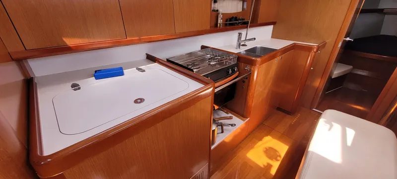 Latika Yacht Photos Pics Interior of 2011 Beneteau Oceanis 43 yacht kitchen with wood finish and modern amenities.