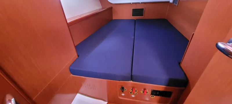 Latika Yacht Photos Pics Cabin interior of 2011 Beneteau Oceanis 43 with blue cushions and wooden finish.