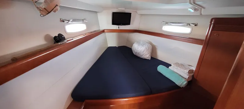 Latika Yacht Photos Pics Cozy cabin interior of 2011 Beneteau Oceanis 43 sailboat with bed and portholes.