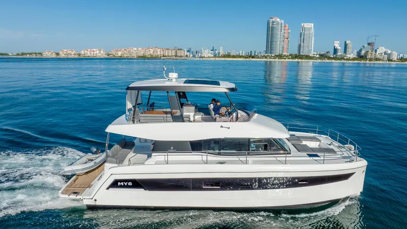 Au Natural Yacht Photos Pics 2023 Fountaine Pajot MY 6 yacht cruising near city skyline.