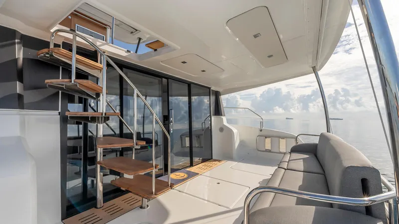 Au Natural Yacht Photos Pics 2023 Fountaine Pajot MY 6 yacht interior with spiral staircase and ocean view.